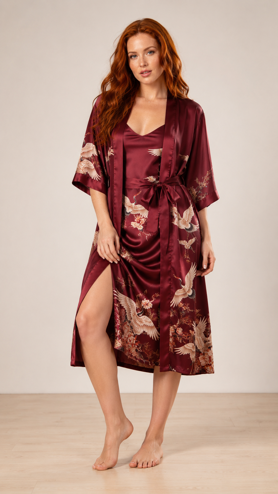 Woman wearing a burgundy satin robe with floral patterns on a neutral background